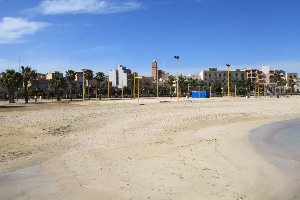 The sandy beach and palm trees at Pretty Bay, Birżebbuġa